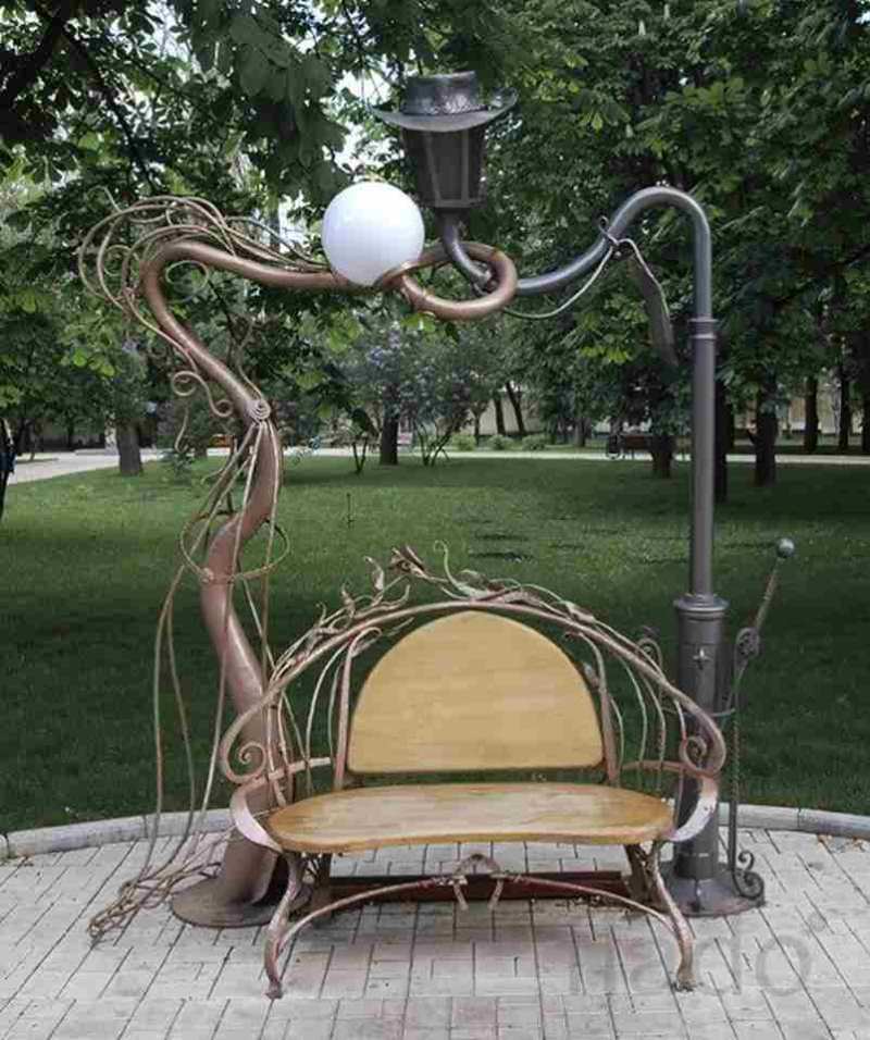 Кованая парковая скамейка и переплетенные фонарные столбы